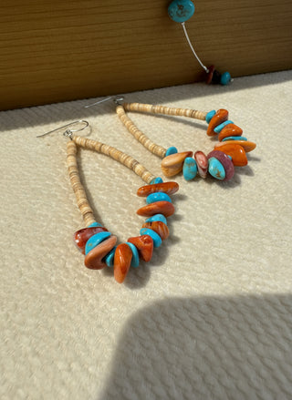 Colorful beaded earrings on a textured surface