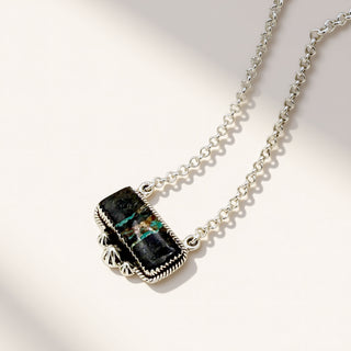 Necklace with a black stone pendant on a light background