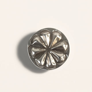 Silver decorative button on a light gray background