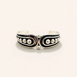 Silver bracelet with black and white accents on a light gray background