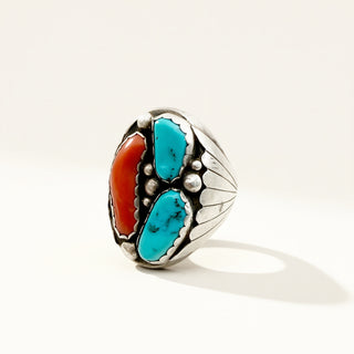 silver ring with red and turquoise stones on a beige background