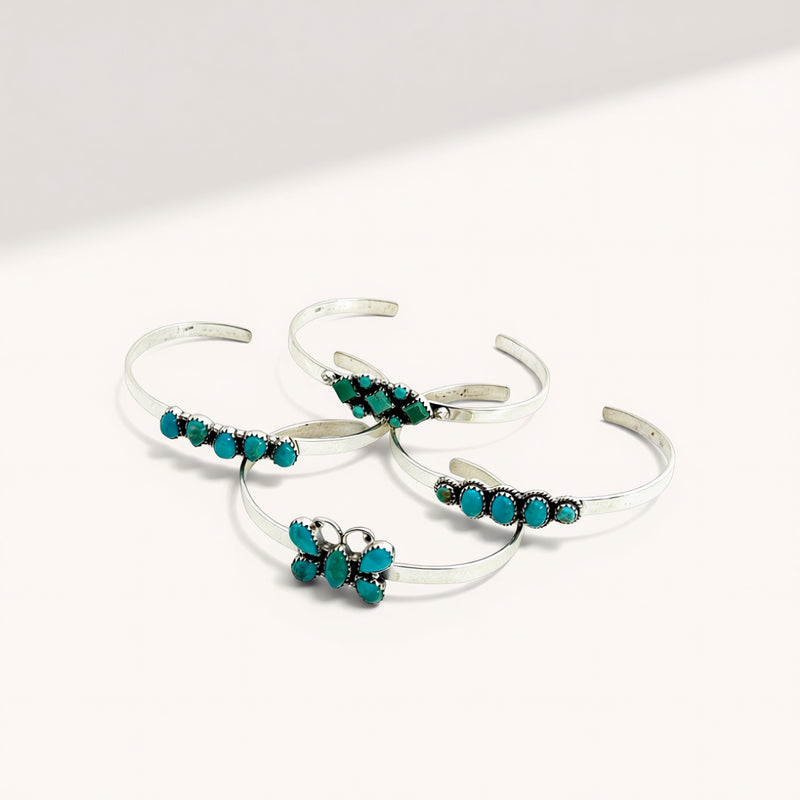 Set of silver bracelets with turquoise stones on a white background