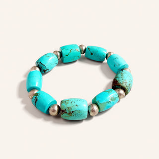 Turquoise beaded bracelet with silver accents on a white background