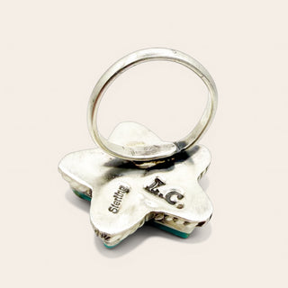 Silver star-shaped keychain with engraved text on a light pink background
