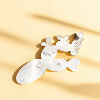 Silver pendant stamp on a beige background