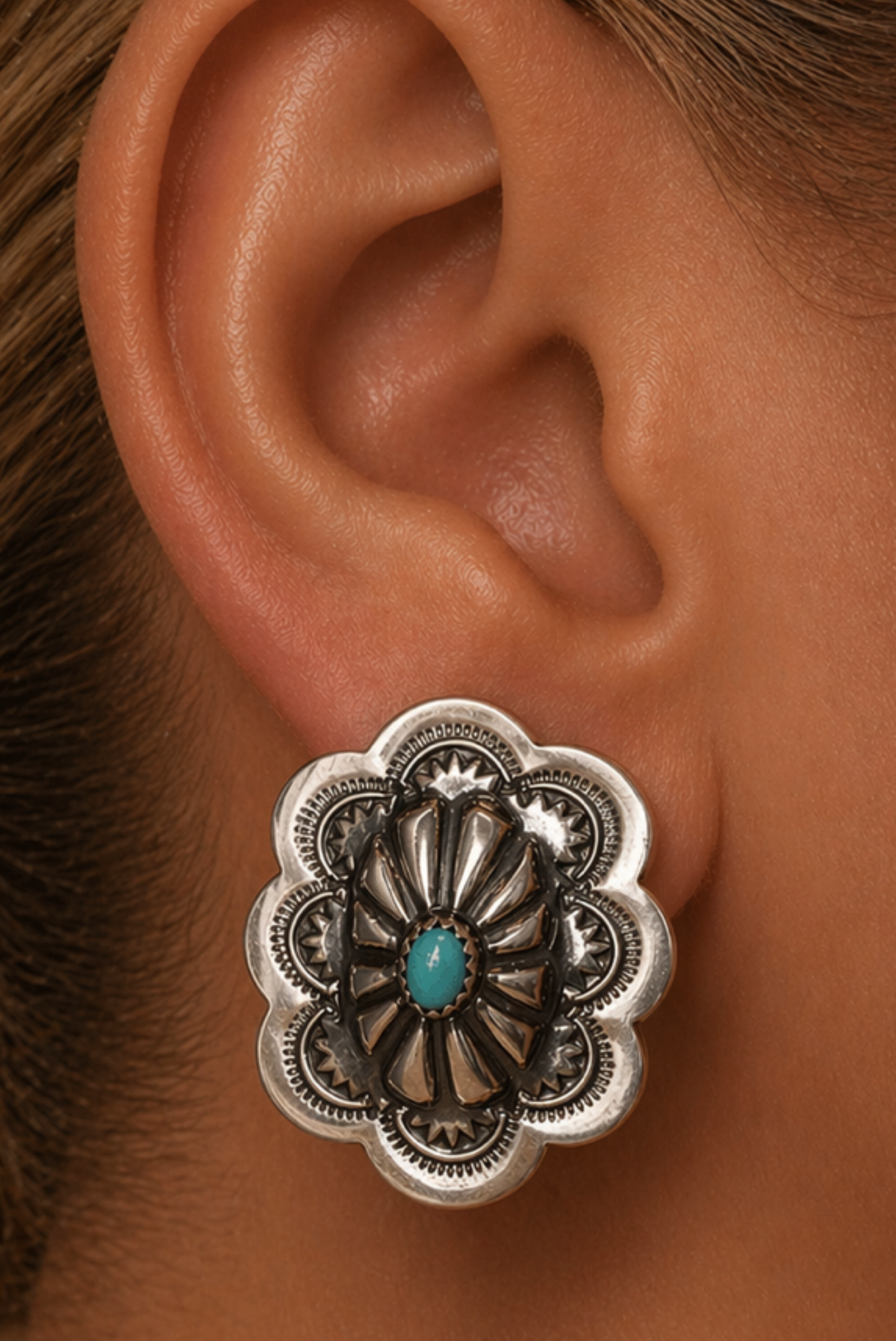 Silver earring on an ear 