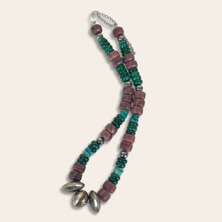 Beaded necklace with pink and green beads and silver accents on a light background