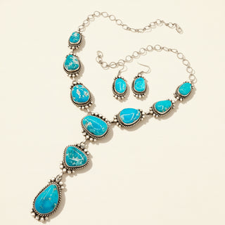 Turquoise earrings and necklace on a beige background