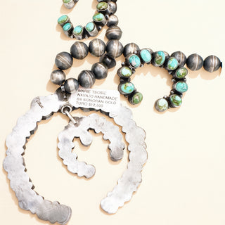 Jewelry set with turquoise beads and silver components on a beige background