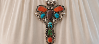 Silver brooch with colorful stones on a beige fabric background