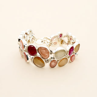 Pink and silver bracelet with stones on a beige background