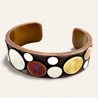 Copper bracelet with circular, multicolored stones on a white background