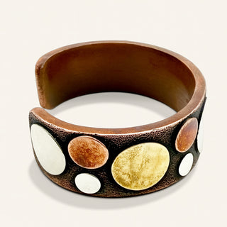 Copper bracelet with circular designs on a white background