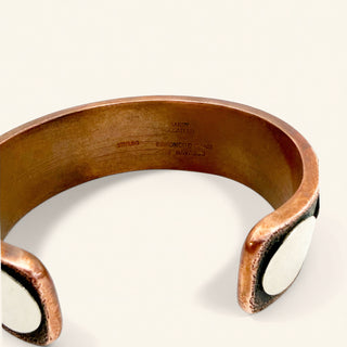 Copper bracelet with white stones on a light background