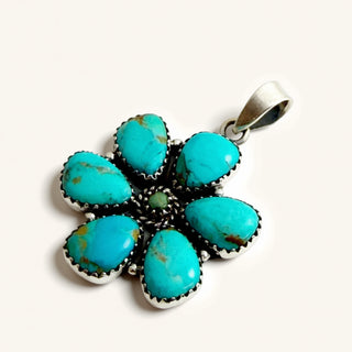 Turquoise pendant with silver setting on a white background