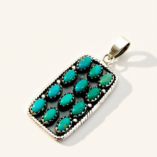 Turquoise pendant with silver setting on a white background