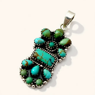 Turquoise pendant with silver setting on a white background