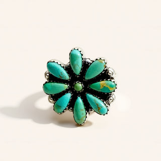 Turquoise flower-shaped ring on a white background