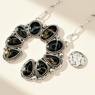 Necklace with black stone pendant on a beige background