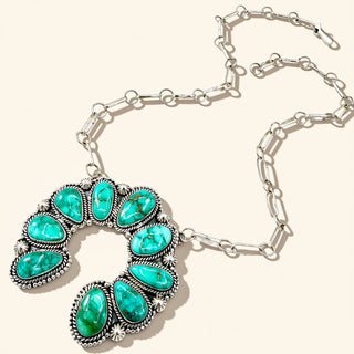 Necklace with turquoise stones and silver chain on a white background