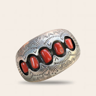 Silver cuff with red stones on a beige background