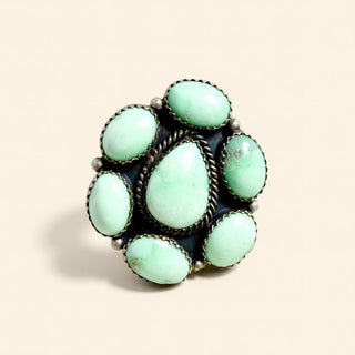Turquoise stone ring with silver band on a beige background