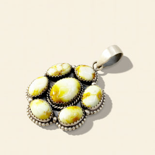 Silver pendant with yellow stone on a beige background