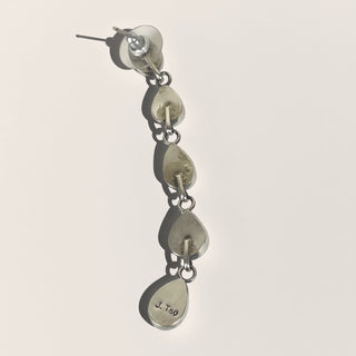 Silver earring with dangling components on a light gray background