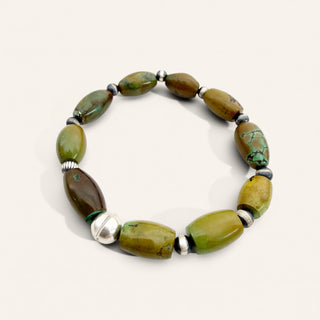 Green beaded bracelet with silver accents on a white background