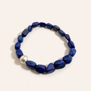 Blue beaded bracelet with a silver clasp on a white background