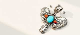 silver pendant with turquoise stone on a beige background