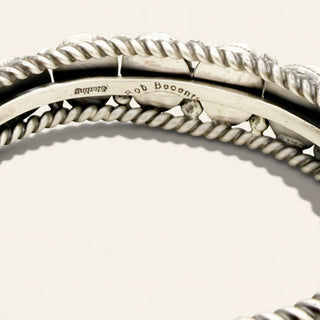 Close-up of a sterling silver rope bangle bracelet with a polished inner band