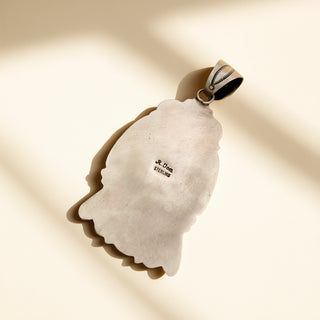 Silver pendant stamp on a beige background