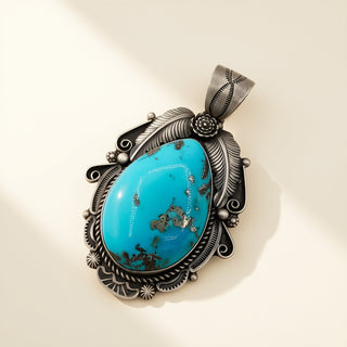 Turquoise stone pendant with silver decorative frame on beige background