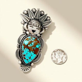 Silver ring with turquoise stone  and coin on a beige background 