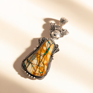 Pendant with a marbled stone and silver frame on a beige background