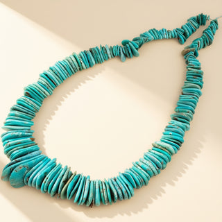 Turquoise flat beaded necklace on a beige background