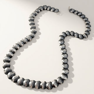 Silver beaded necklace on a white background