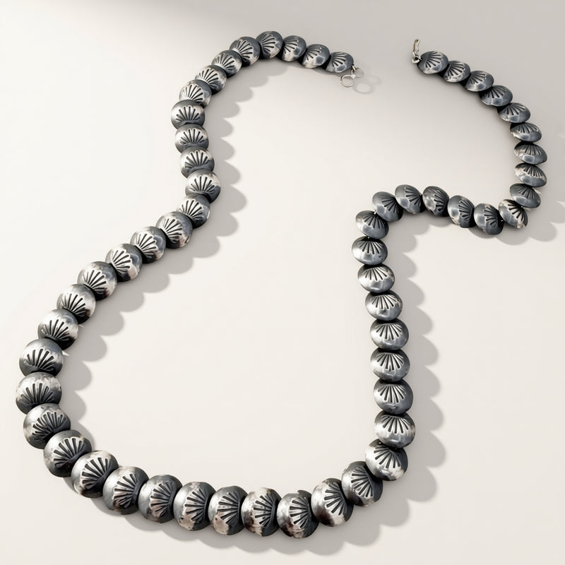 Silver beaded necklace on a white background