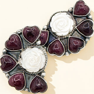 Earrings white rose centers and purple heart-shaped stones on a beige background