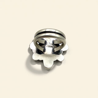 Silver ring with 'S.Tsuo' engraving on a beige background