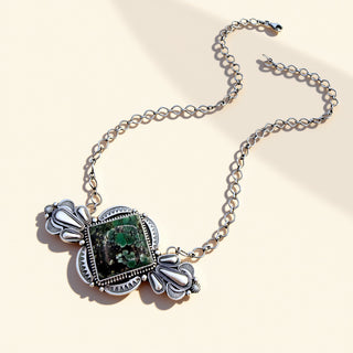 Necklace with a green stone pendant on a beige background