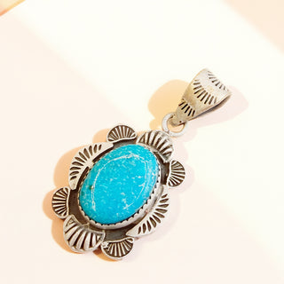 Turquoise pendant with silver frame on a white background