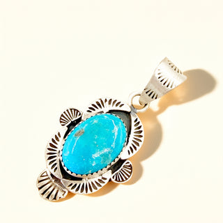 Turquoise pendant with silver setting on a white background