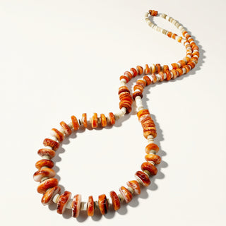 orange beaded necklace on a beige background