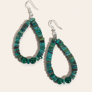 Teardrop-shaped turquoise beaded earrings on a light background