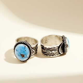 Two silver rings with blue stones on a beige background