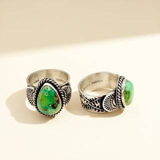 Silver rings with green stones on a beige background