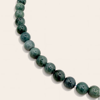 green beaded jewelry on a beige background 