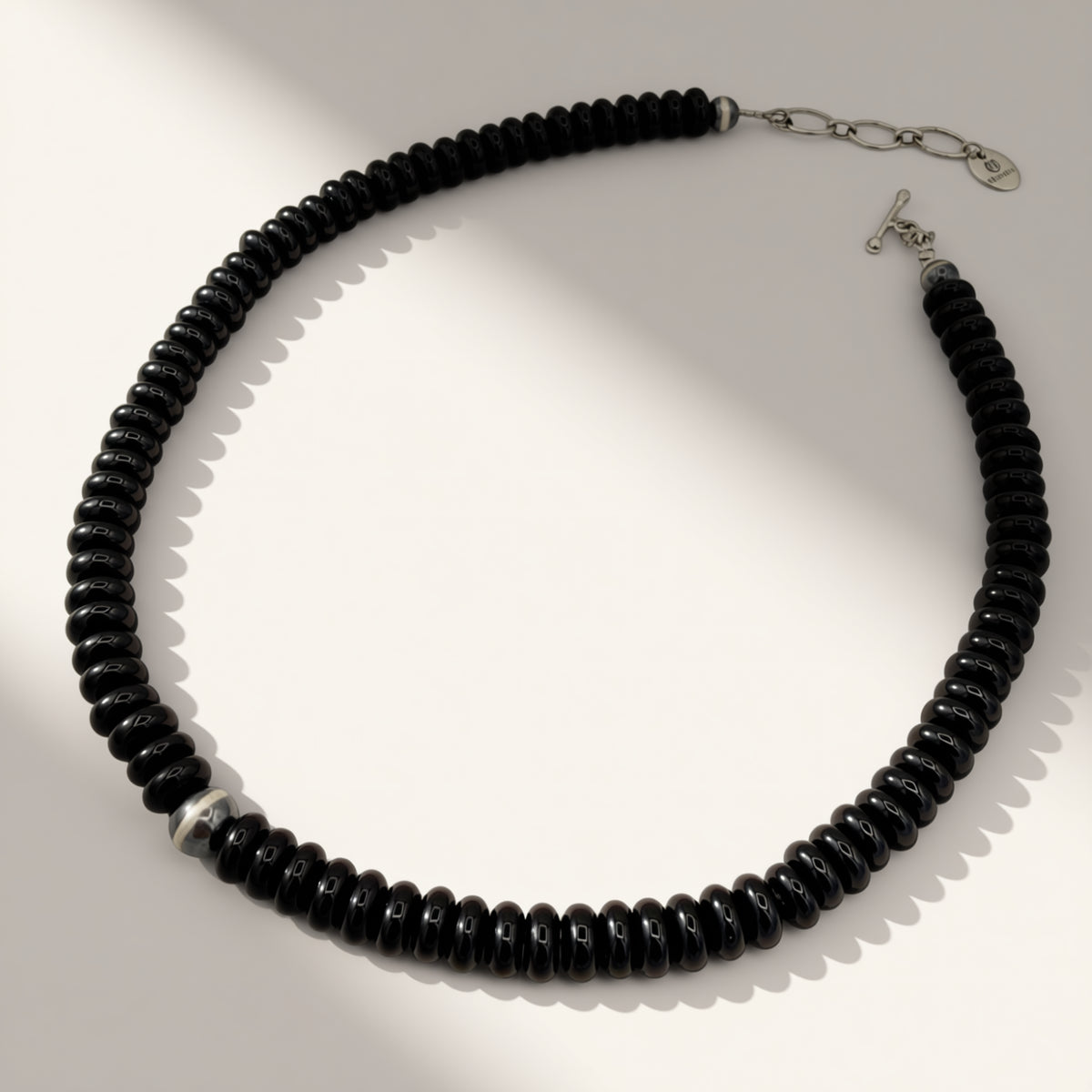 black beaded necklace on a beige background